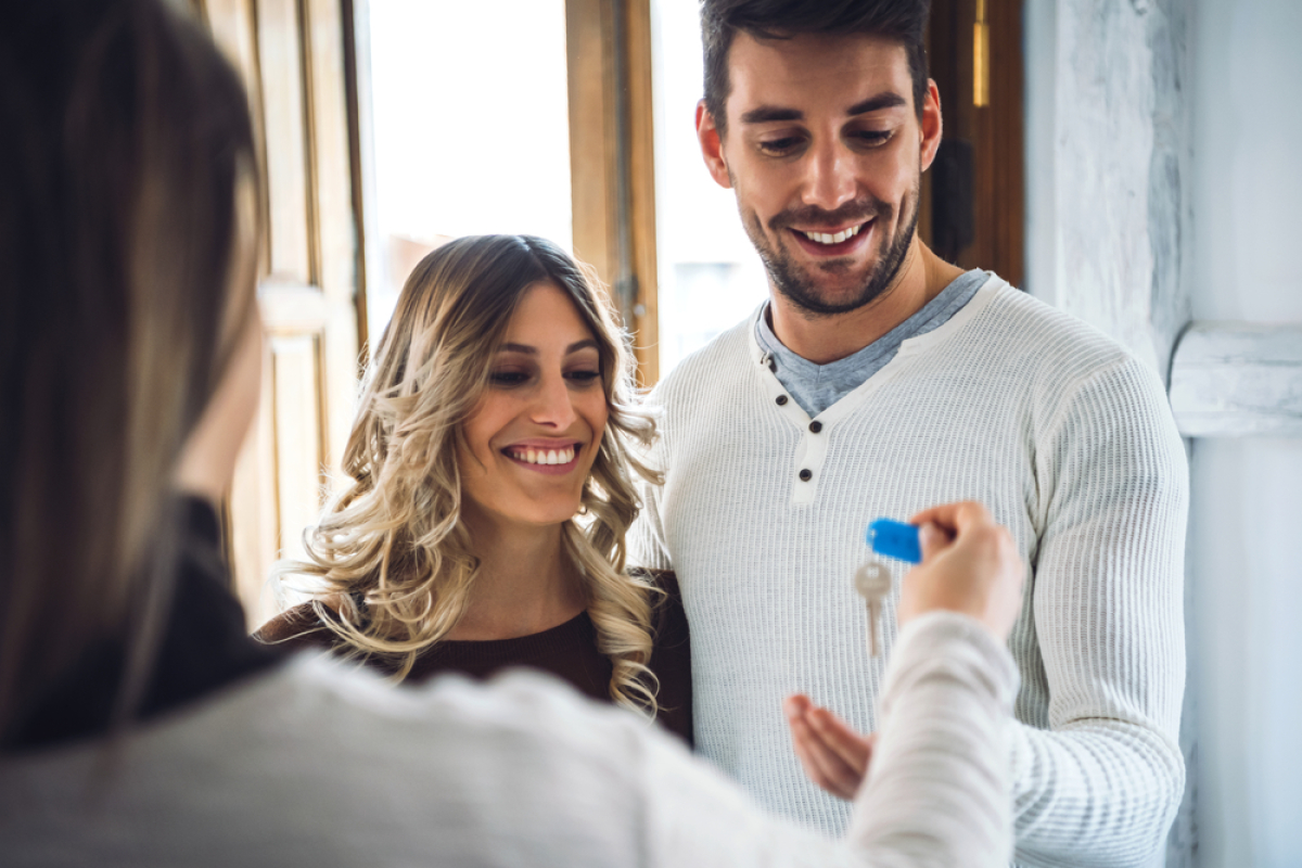 Louer un logement acheté avec PTZ — Un couple heureux récupère des clés