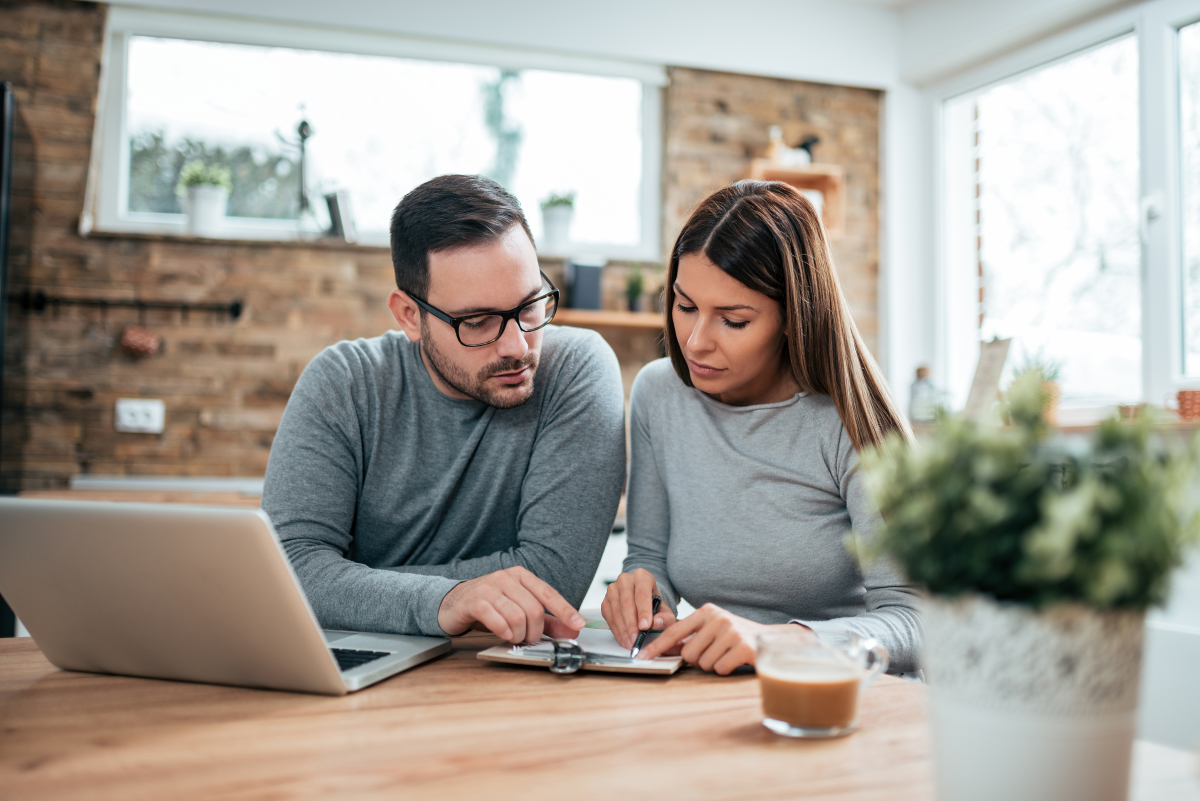 un couple fait des calculs dans sa cuisine
