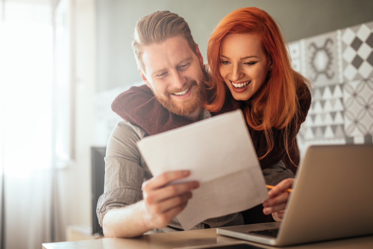 Crédits immobiliers à Toulouse - Un couple heureux lit un document