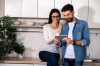 Un couple regarde une tablette numérique dans une cuisine