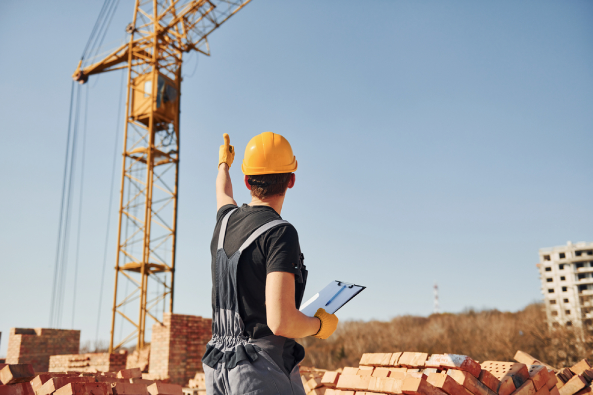 Un maître d’ouvrage faisant signe à une grue sur un chantier