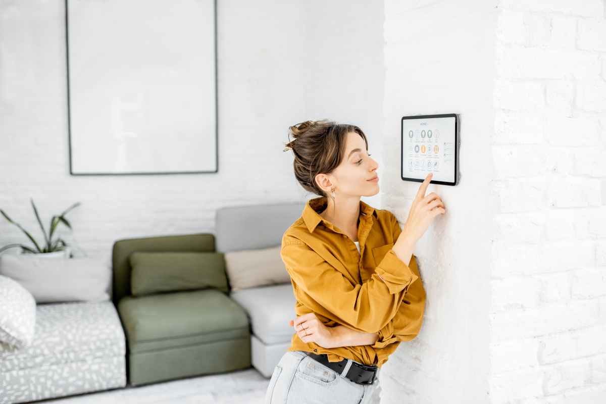 objet connecté  –  femme pilotant son logement connecté depuis une tablette