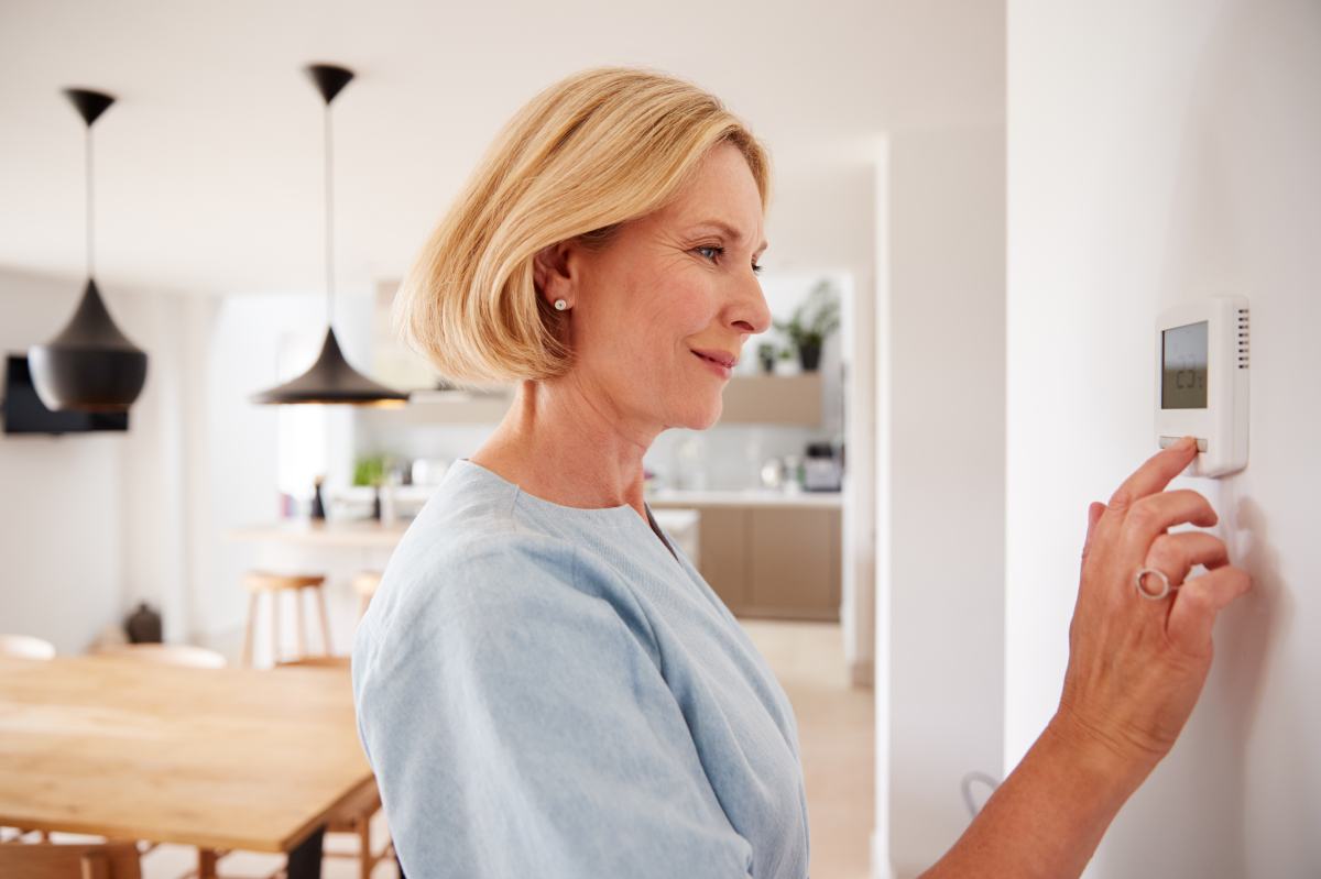 objet connecté  –  femme allumant l’alarme connectée de son logement depuis une commande centralisée