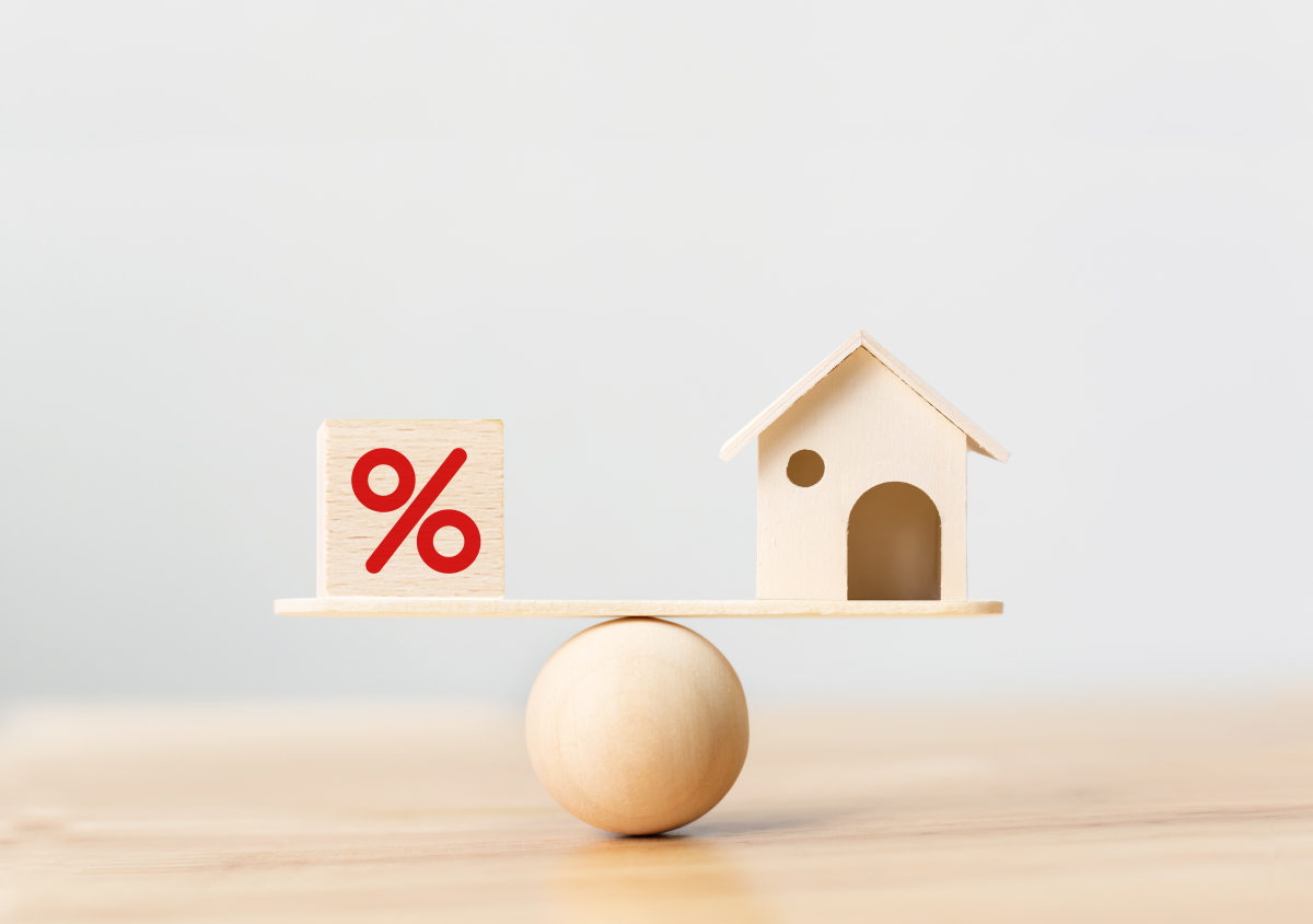Baisse des taux BCE 2024 — Une maison miniature en équilibre avec un symbole pourcentage