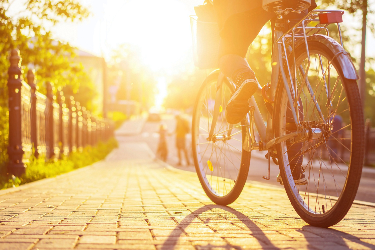 Vélo roulant sur un trottoir au coucher du soleil
