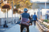 Homme avec une sacoche circulant en vélo dans une ville