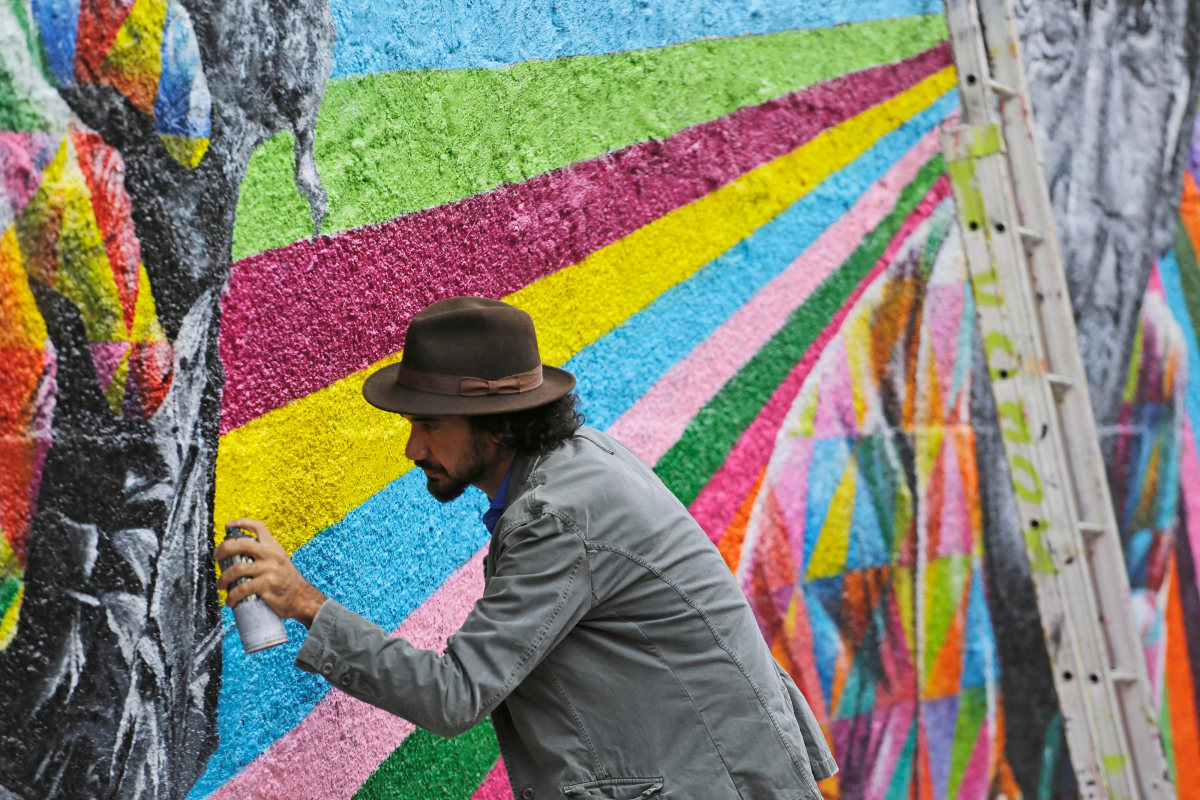 QPV à Toulouse – Homme réalisant une fresque murale colorée dans une rue