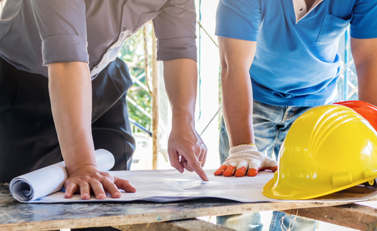 Travaux Modificatifs Acquéreurs – Deux ouvriers de chantier examinent un plan