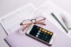 Investissement LMNP Toulouse - Photo de comptabilité avec une calculatrice et des lunettes posées sur un bureau