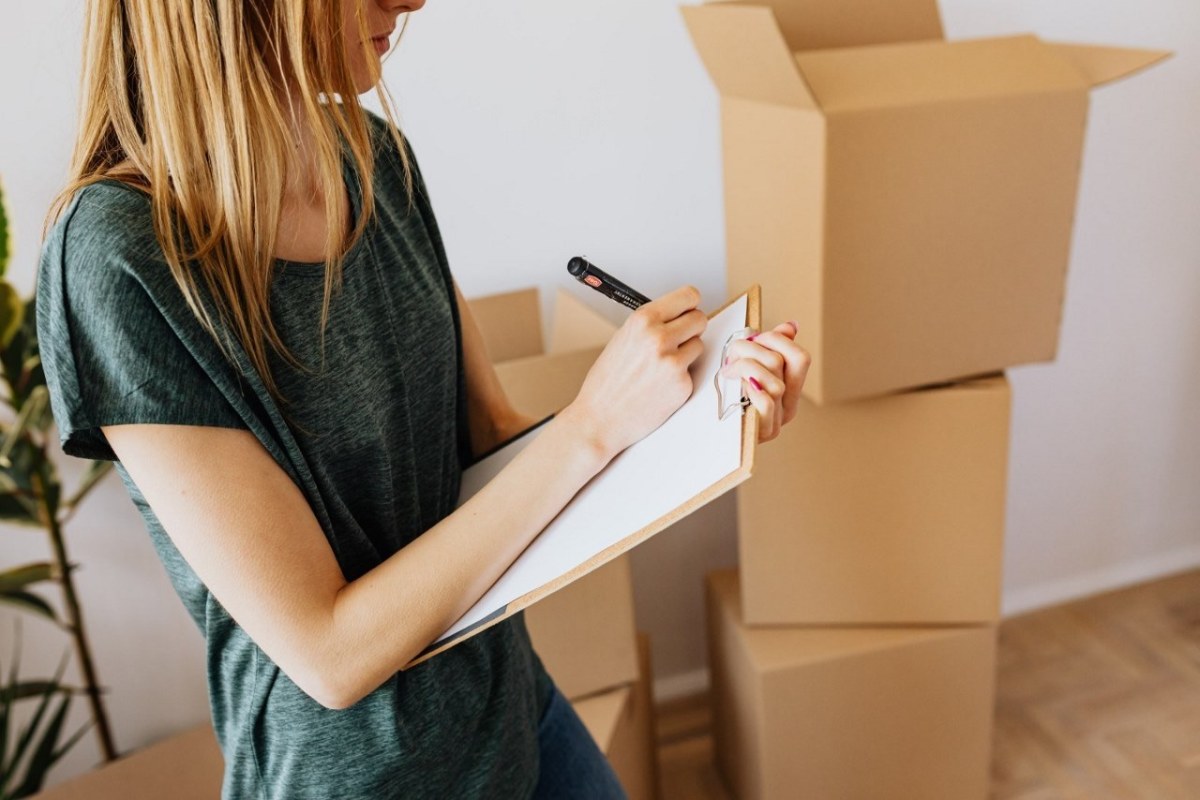 Investissement LMNP Toulouse - Une femme prend des notes dans son appartement en plein déménagement