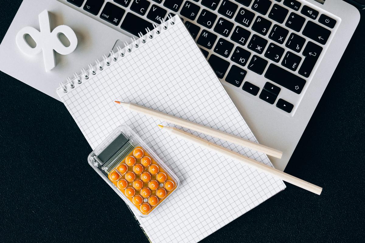  devenir propriétaire à Toulouse – une calculatrice et un carnet posés sur le clavier d’un ordinateur portable 