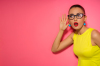 résiliation assurance emprunteur – une femme habillée de couleurs pop tend l’oreille