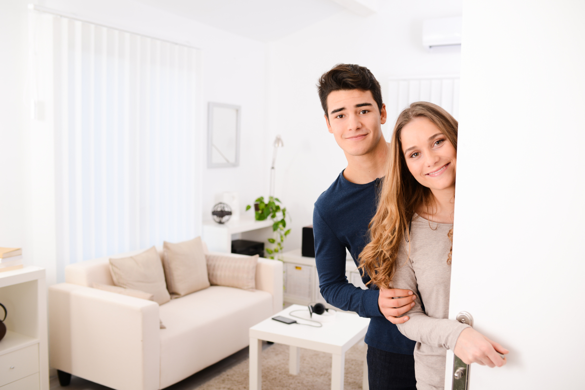Trouver un logement étudiant à Toulouse – un jeune couple ouvre la porte de son logement