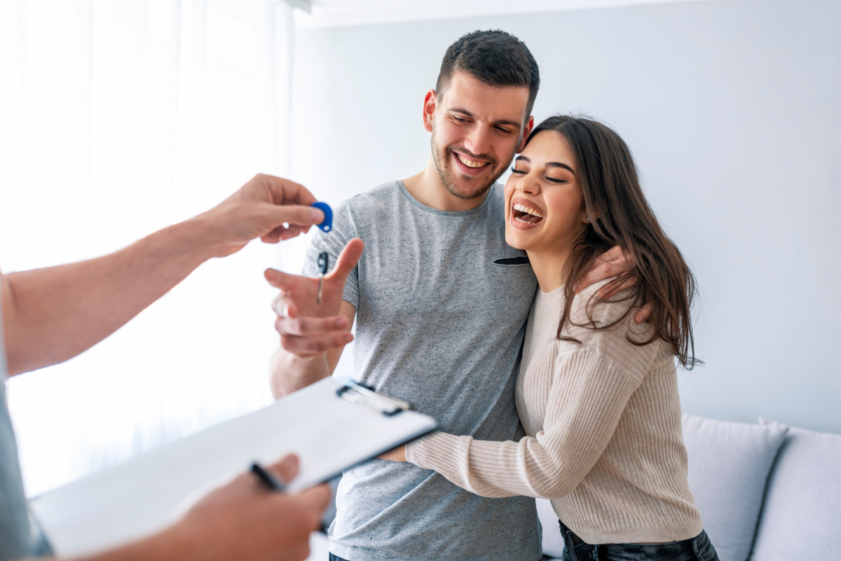Prêt Immobilier Mariage – un couple sourit au cours d’une remise de clés
