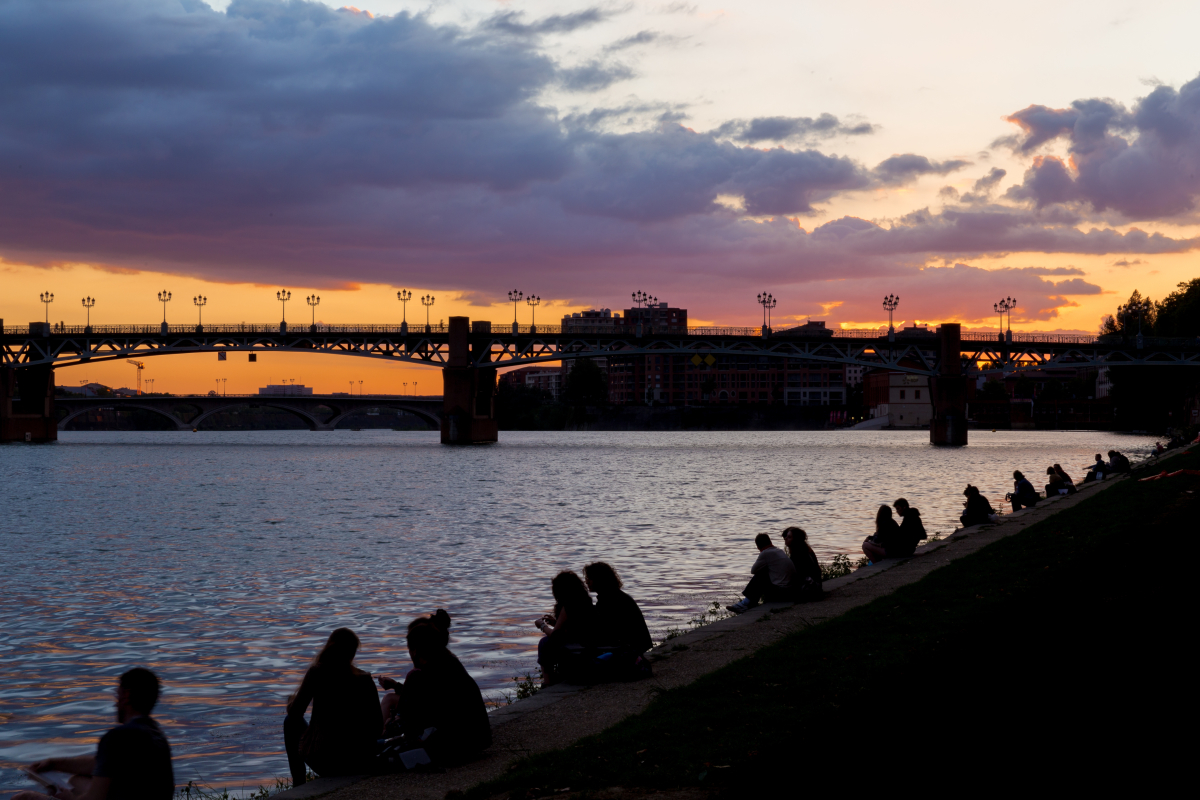 Loyer appartement toulouse – Des étudiants profitant d’un coucher de soleil sur la Garonne