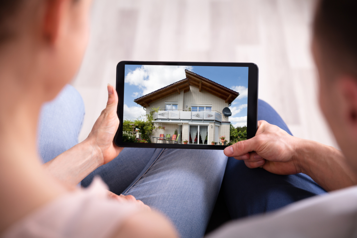 Maison neuve clé en main – Un couple regardant sa nouvelle maison sur une tablette