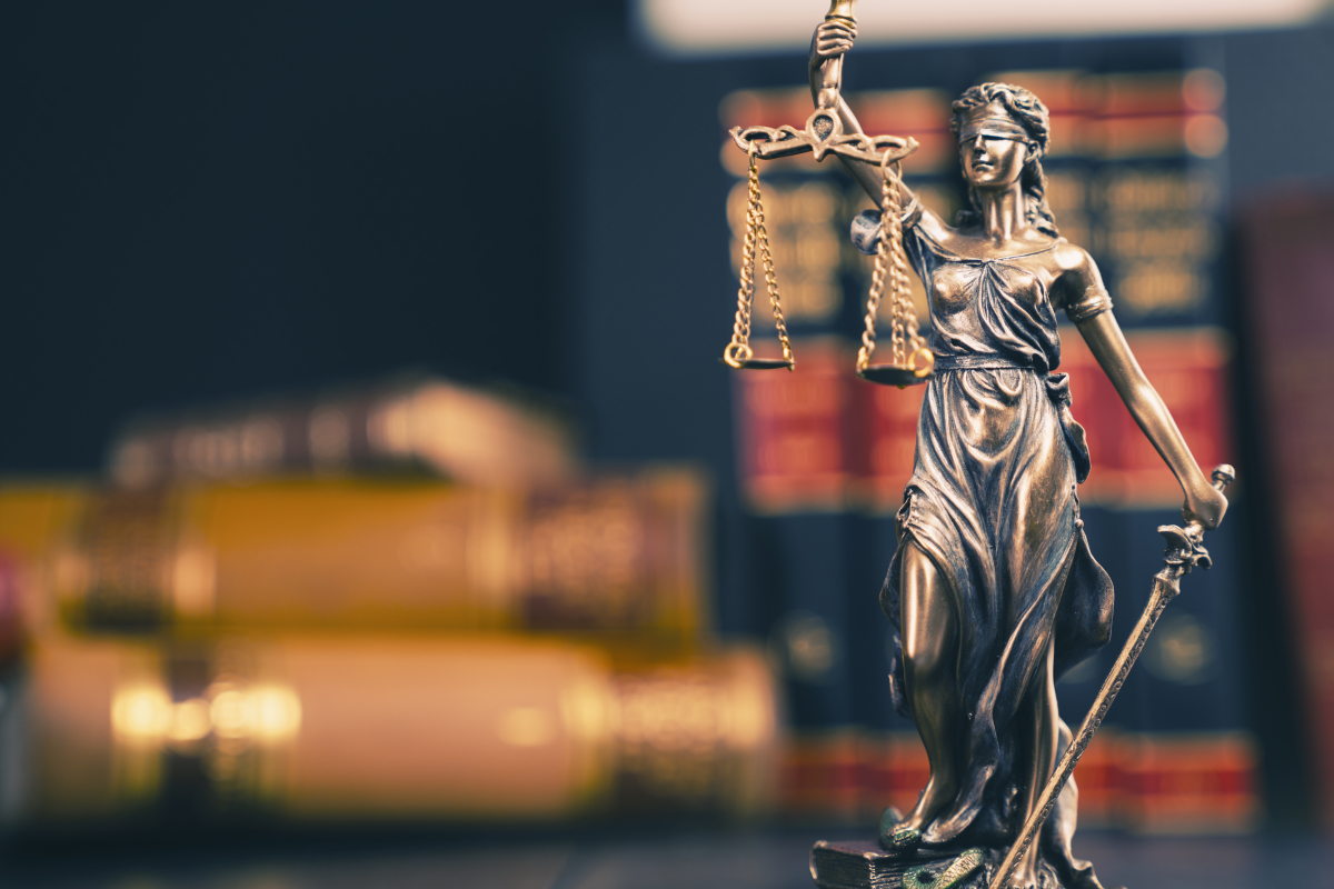 Changement de propriétaire locataire — une statue représentant la justice devant des livres juridiques