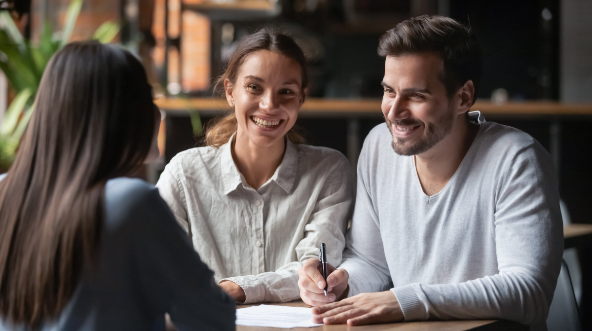 nouveau calcul taux d’endettement — Un couple en rendez-vous avec leur courtier en immobilier neuf