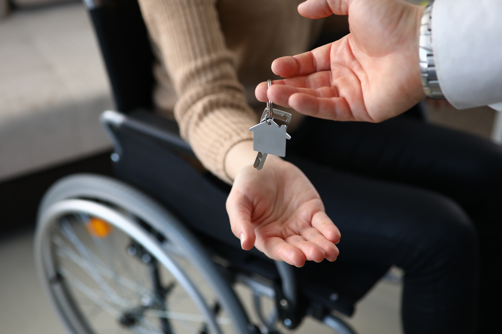 Remise de clés à une personne en fauteuil