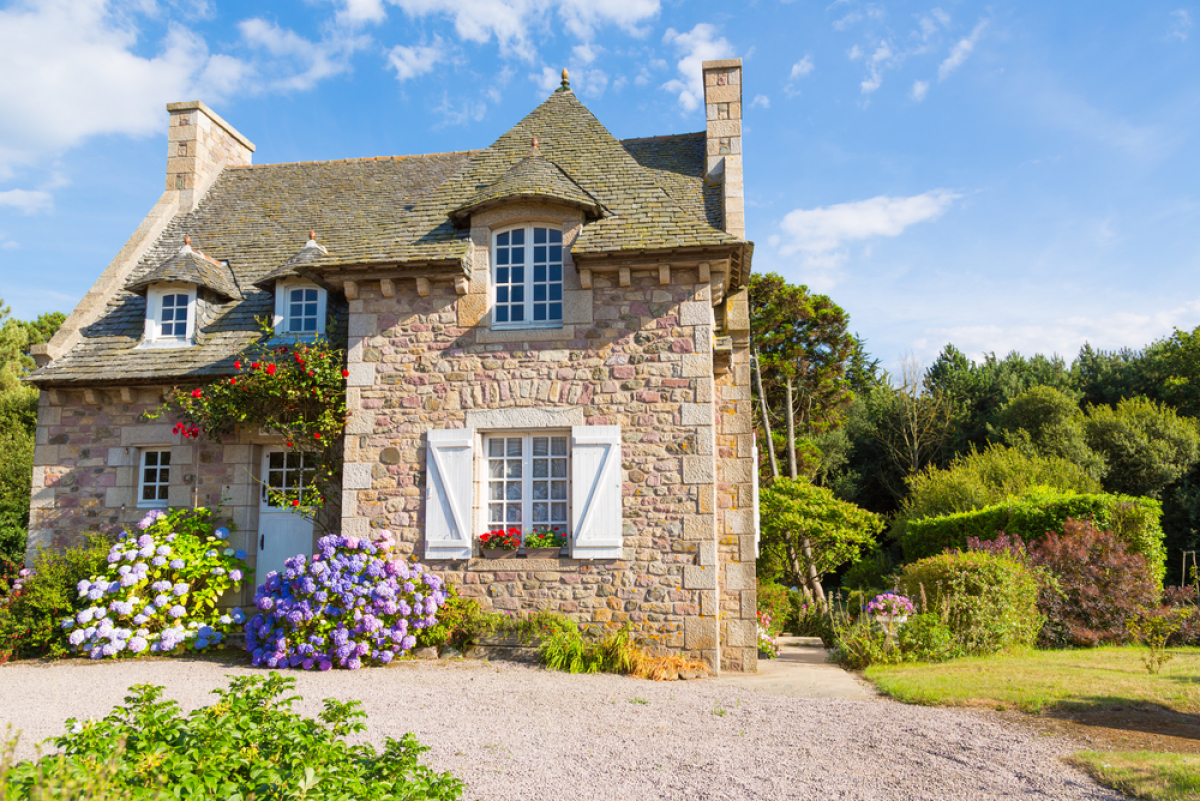 une maison en pierre ancienne au cœur d’un jardin fleuri