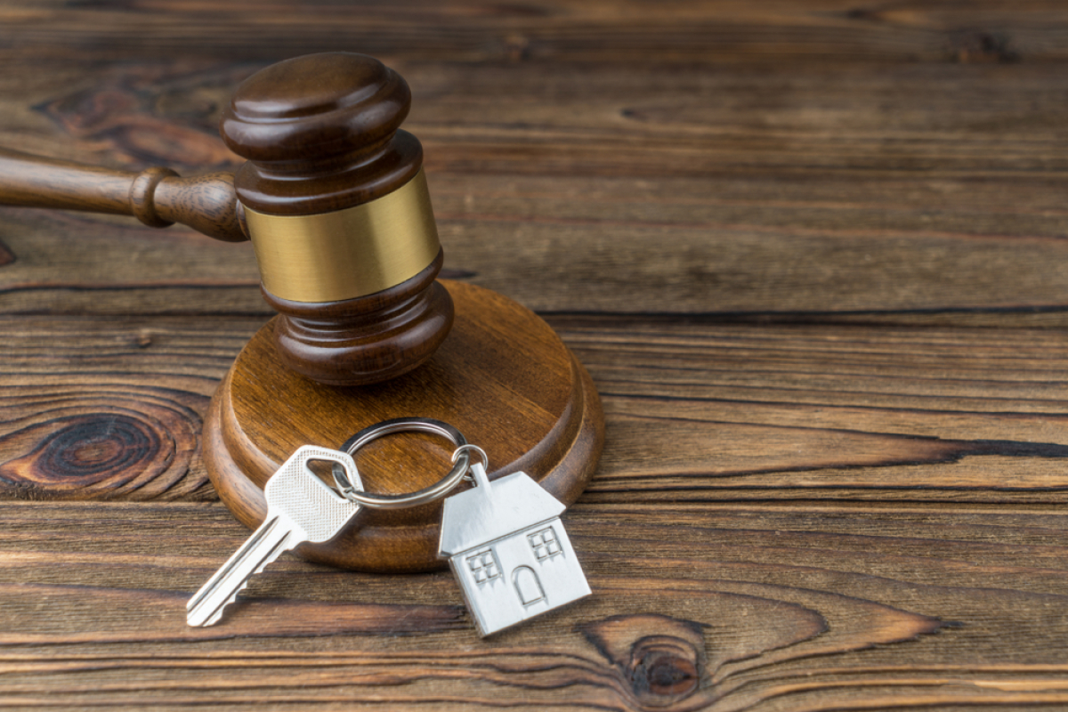 Faux dossier location — des clés de maison à côté d’un marteau de juge