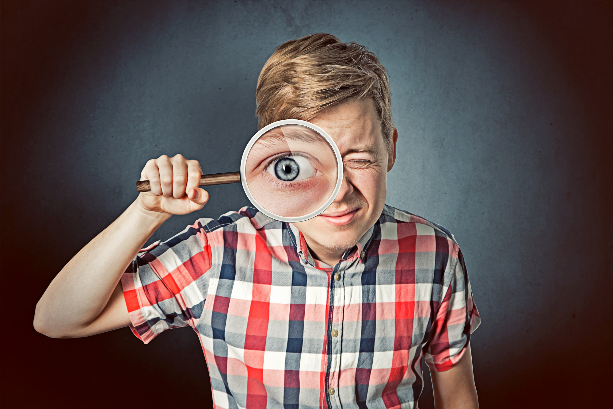 Un garçon regarde dans une loupe