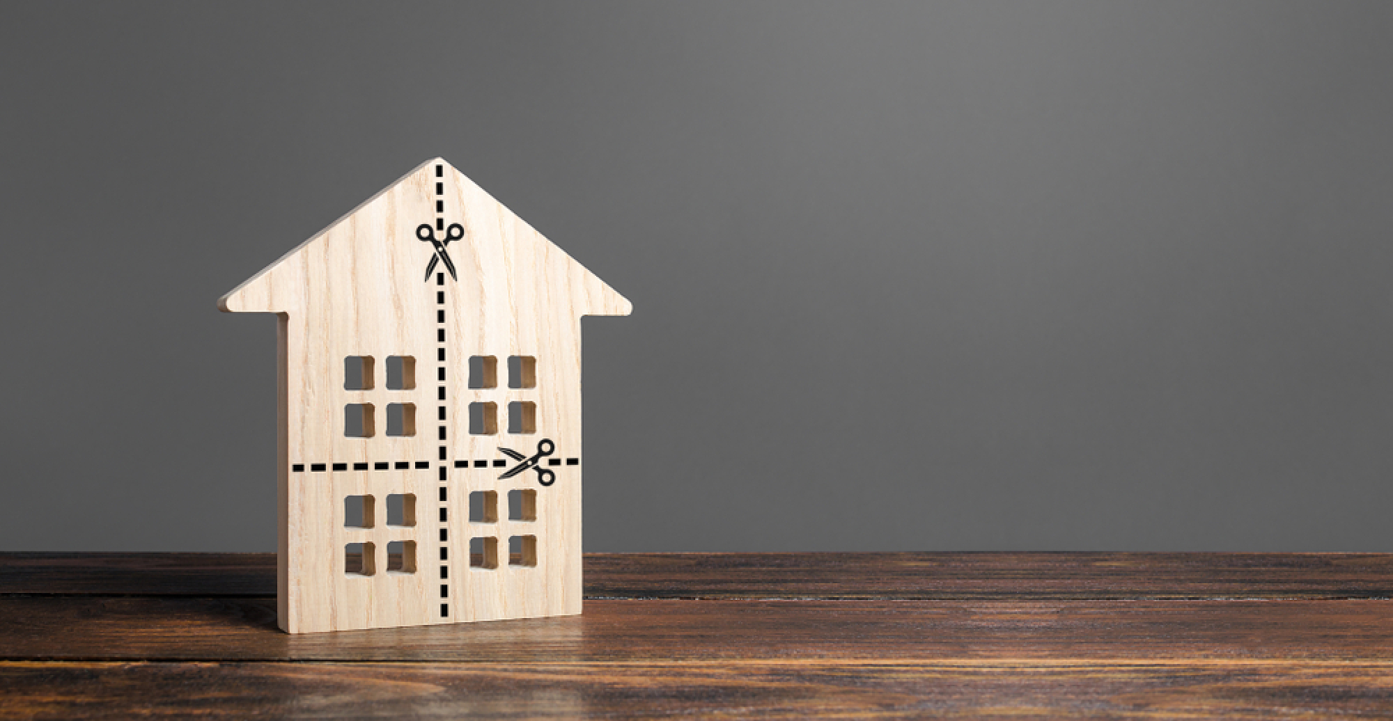 Une maison miniature en bois avec des pointillés de découpe dessinés dessus