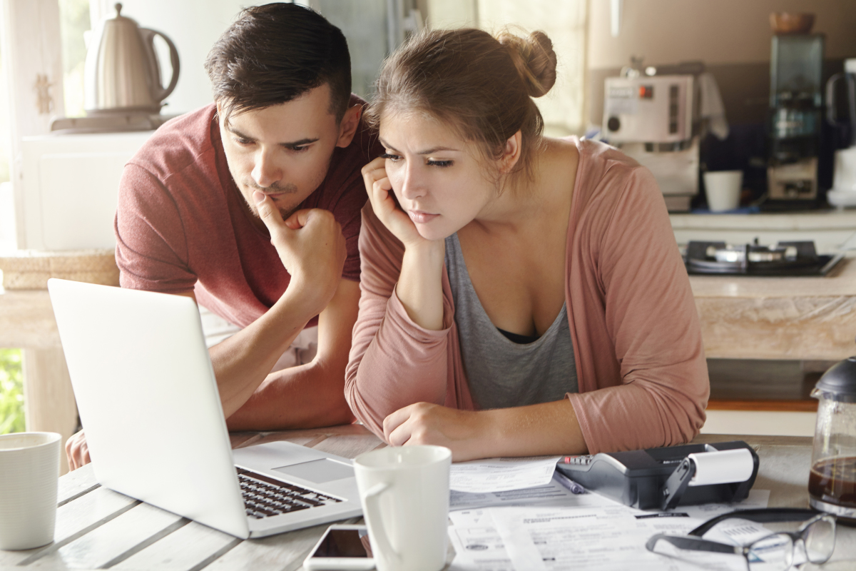 Comment réduire les charges de copropriété – Deux personnes en couple font des recherches sur un ordinateur