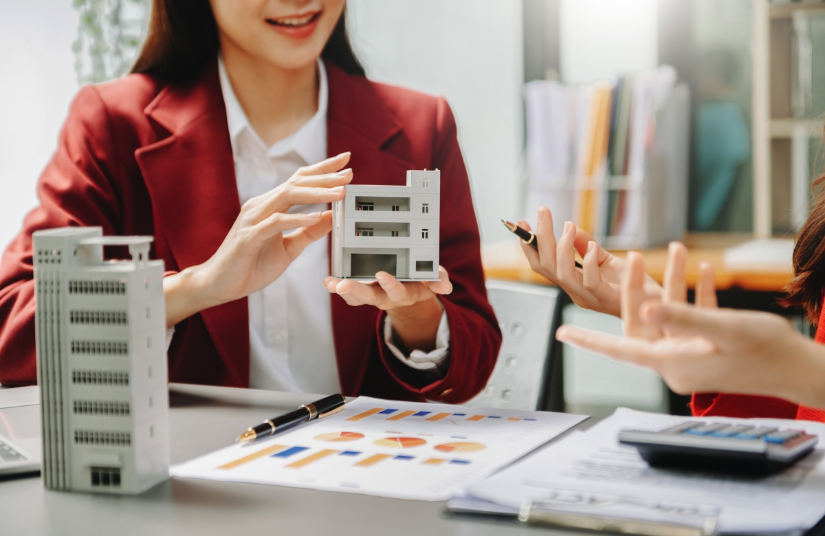 Loi Pinel 2024 — Une femme présente une maquette d’un programme immobilier neuf