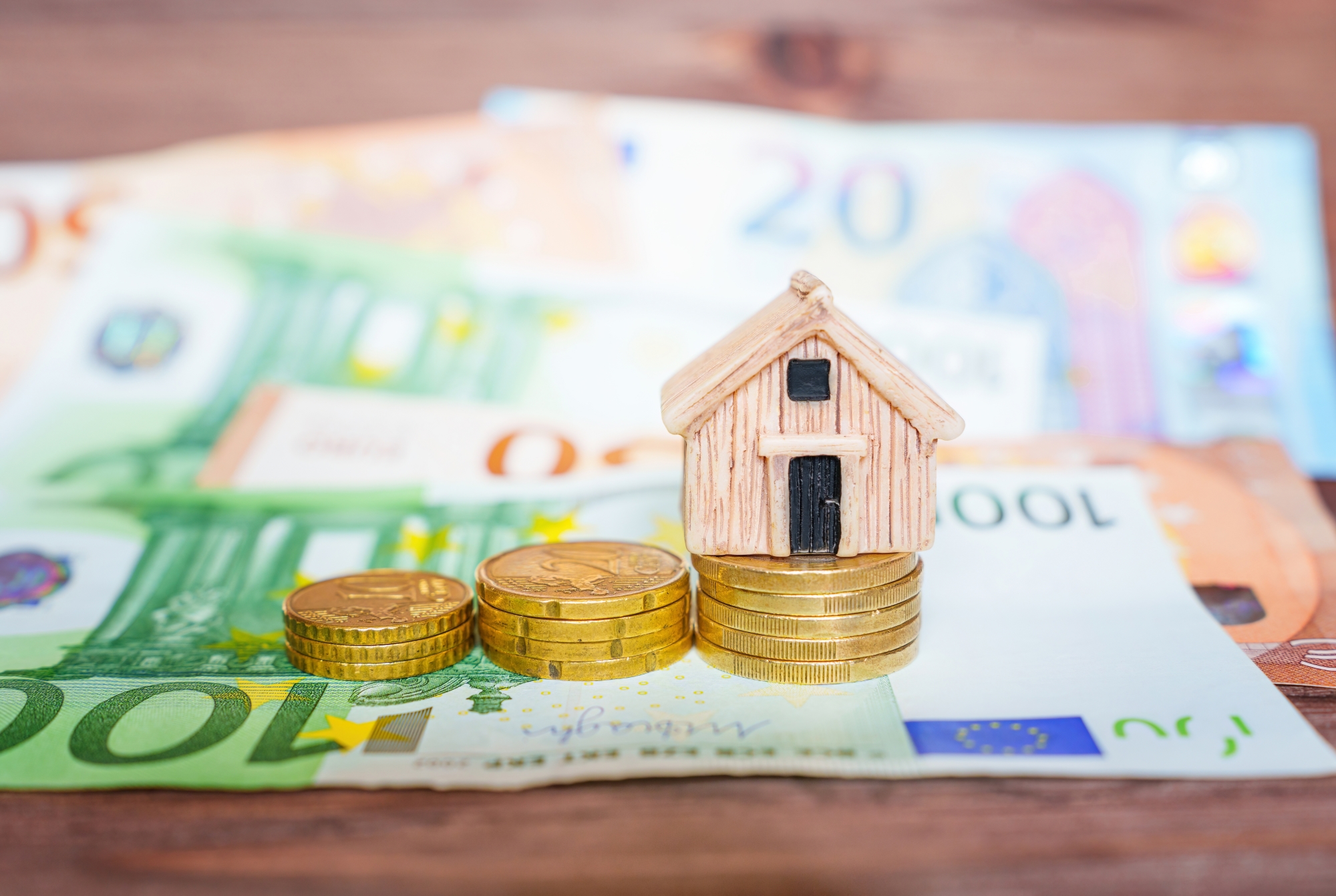 une maison de bois sur un tas de pièces et de billets