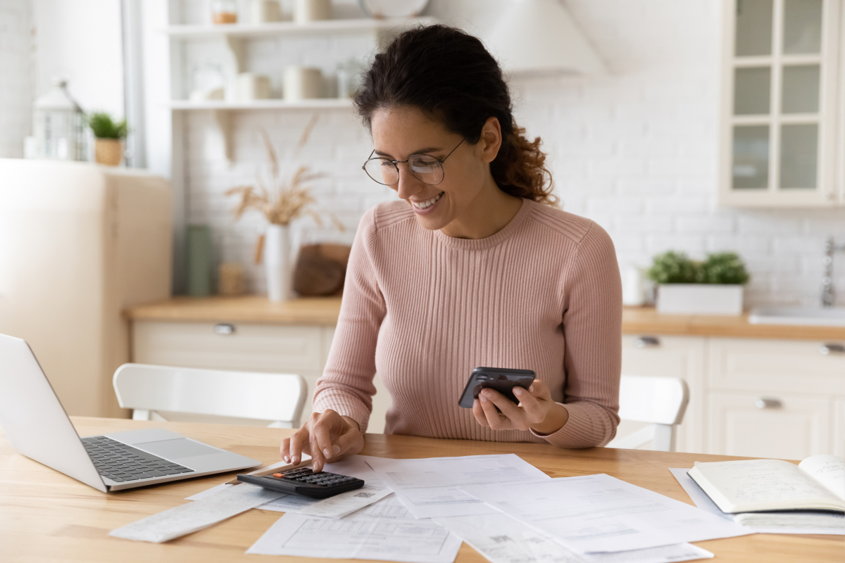 Dépenses à éviter crédit immobilier — une femme faisant les comptes en souriant