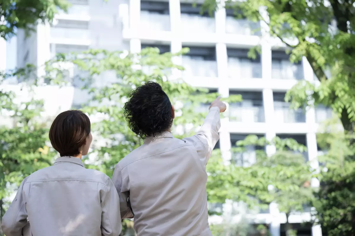  un couple montrant du doigt un immeuble neuf 