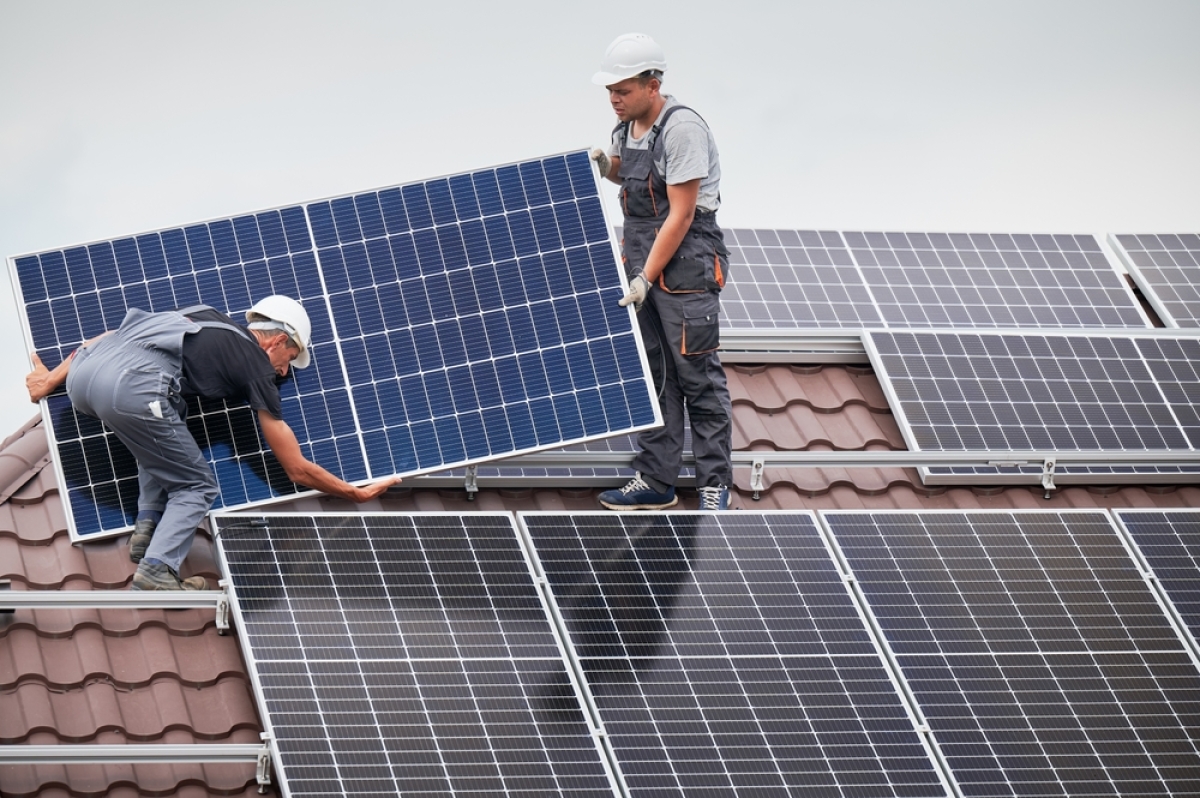 analyse cycle de vie bâtiment – des ouvriers posent des panneaux solaires sur un toit