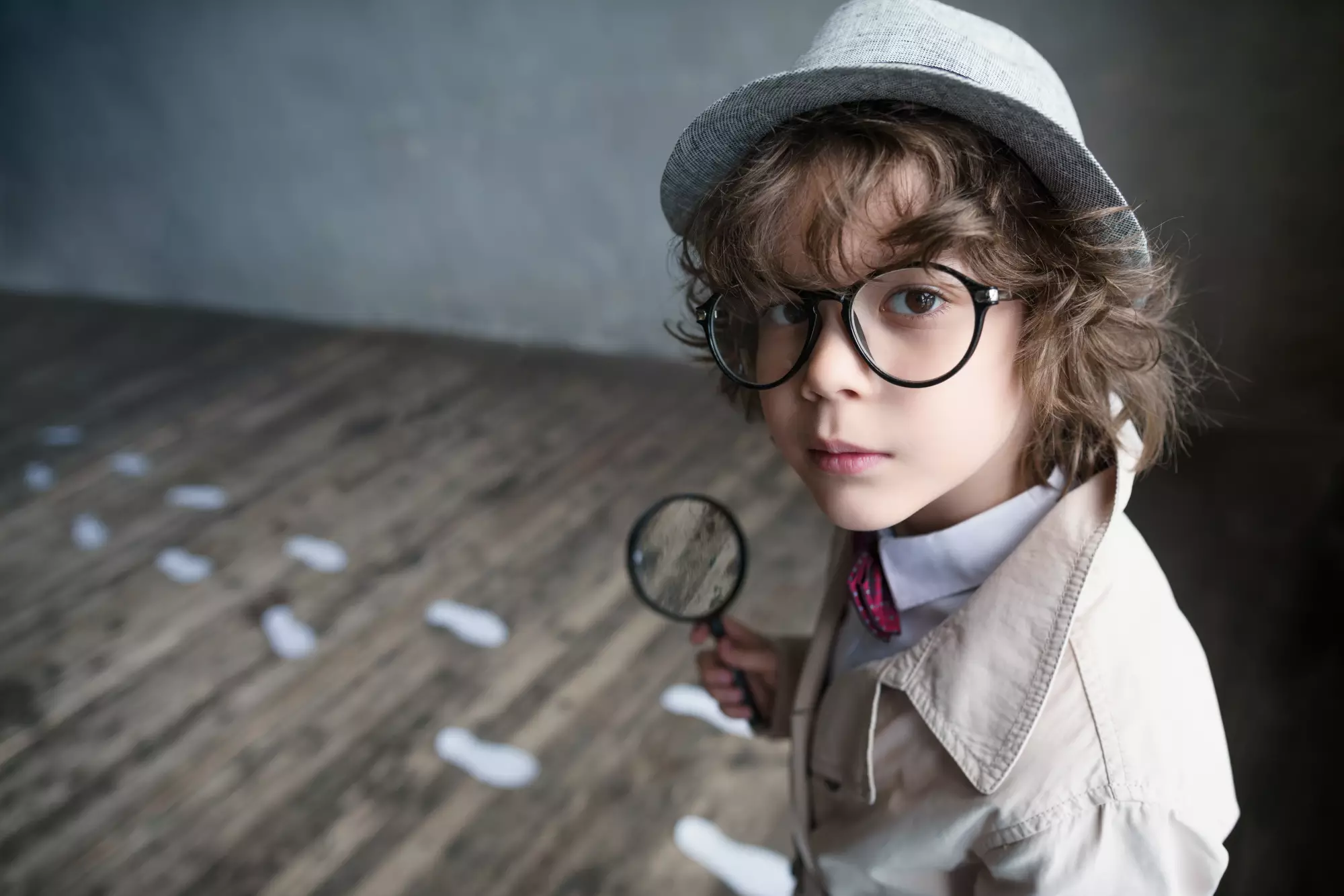 un enfant déguisé en enquêteur avec une loupe