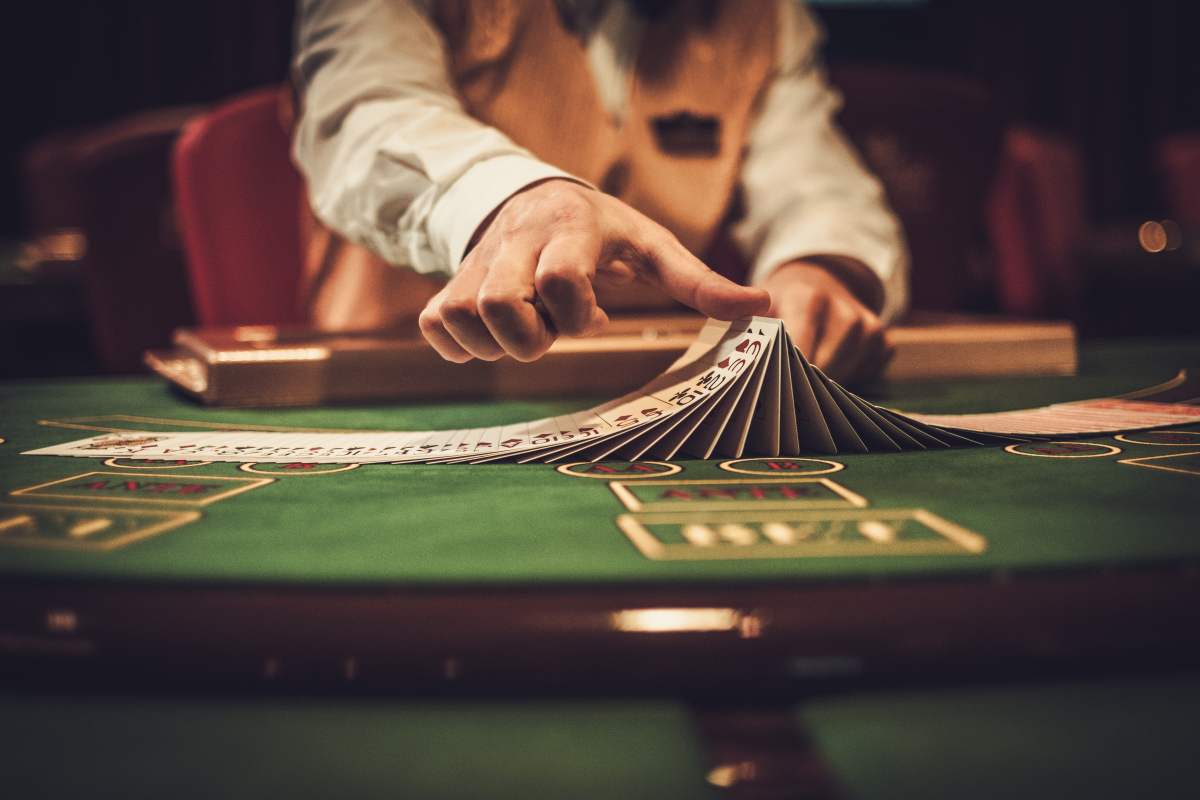 Dépenses à éviter crédit immobilier — un croupier retourne des cartes sur une table de blackjack dans un casino