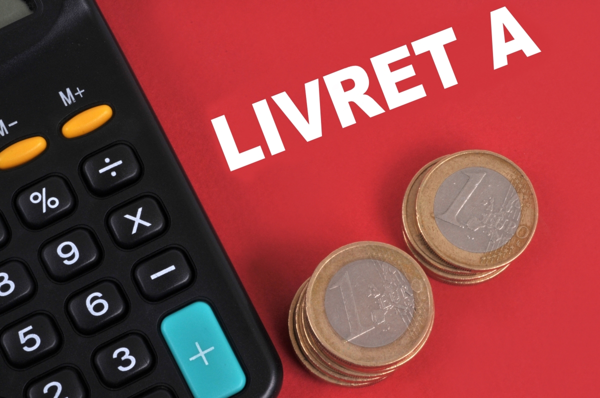 Baisse des taux BCE 2024 — Une calculette et des pièces de monnaie posées sur un livret A