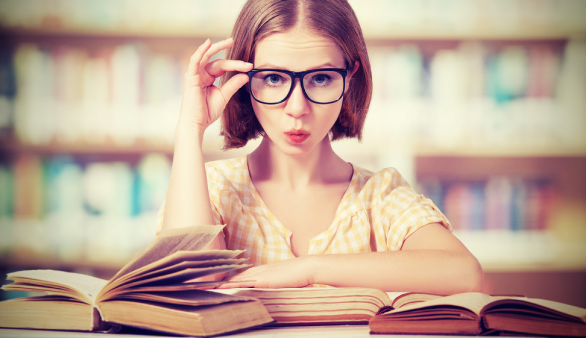 une jeune femme avec des lunettes dans une bibliothèque