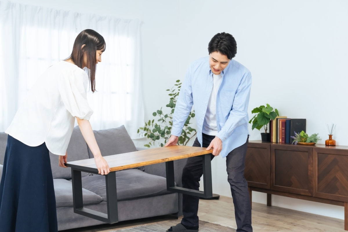 la déclaration en location meublée est différente de celle en location nue de même que les charges défiscalisables. un couple installe des meubles dans le salon d'un appartement