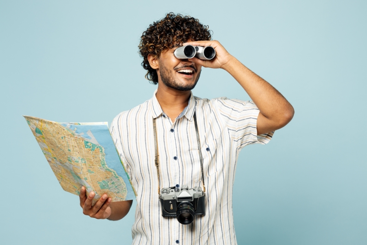 après la rupture de votre contrat, plusieurs questions portent à vous. un jeune homme regarde l'horizon avec des jumelles et tient une carte géographique