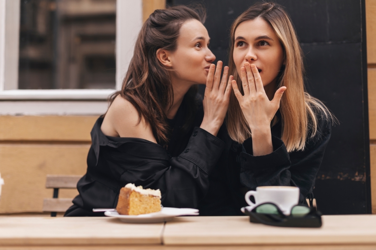 2 femmes se disent des secrets à l'oreille